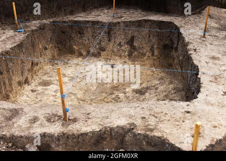 Archaeological work, archaeologists dug a hole in field to search for historical artifacts and finds Stock Photo