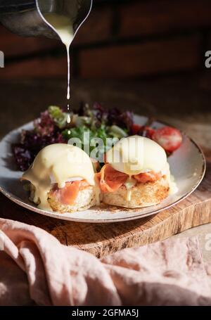 Eggs Benedict with smoked salmon, Hollandise sauce on bread Stock Photo