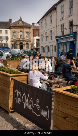UK, England, Derbyshire, Ashbourne, Market Place, Victoria Square, White Swan pub customers outside in sunshine Stock Photo