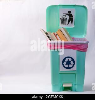 basra, iraq - august 22, 2021: Photo of books and novels  in a plastic trash bin Stock Photo