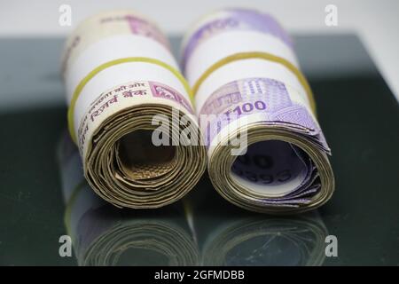 Indian currency note rolls and placed on glass table Stock Photo