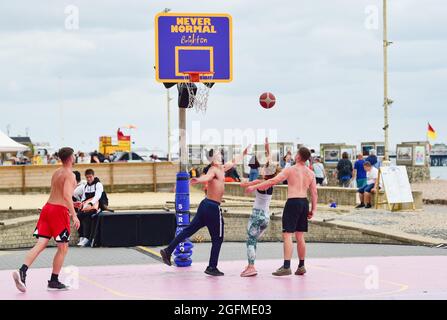 Brighton UK 26th August 2021 - Basketball players enjoy the warm afternoon sunshine on Brighton seafront with hot sunny weather forecast for the forthcoming bank holiday weekend : Credit Simon Dack / Alamy Live News Stock Photo