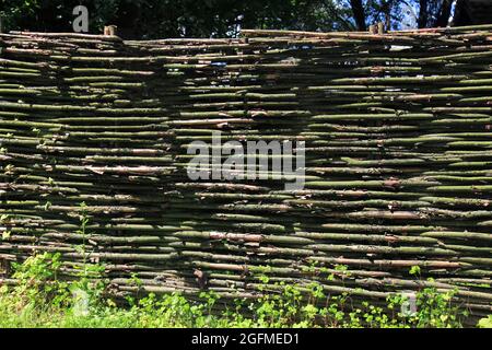 The texture of a fence woven from branches, vines, twigs and sticks. Natural old fences from improvised means. Modern landscaping and decor Stock Photo