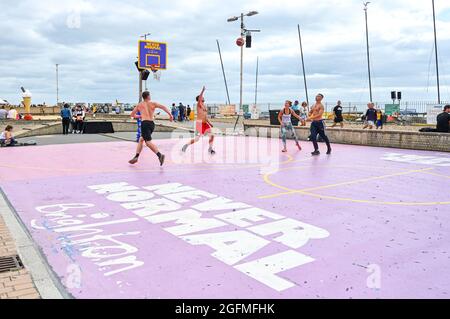 Brighton UK 26th August 2021 - Basketball players enjoy the warm afternoon sunshine on Brighton seafront with hot sunny weather forecast for the forthcoming bank holiday weekend : Credit Simon Dack / Alamy Live News Stock Photo