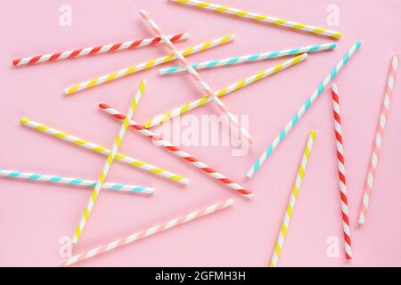 Drinking straws for party on pink background. Top view of colorful paper disposable eco-friendly straws for cocktails. Flat lay. Stock Photo