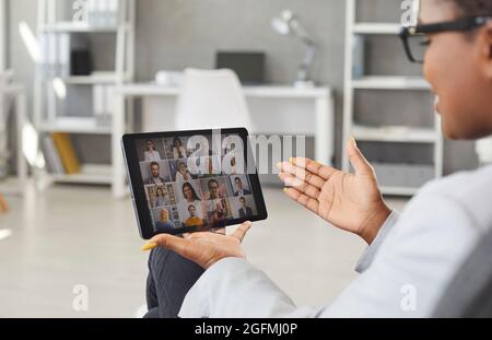 Black woman having online meeting with her business team via video call on tablet Stock Photo
