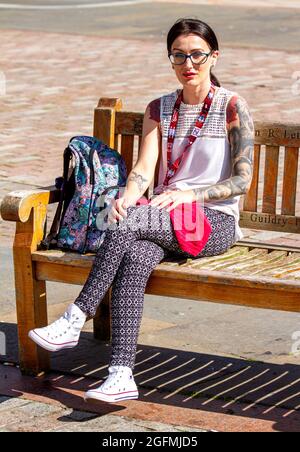 Dundee, Tayside, Scotland, UK. 26th Aug, 2021. UK Weather: A warm sunny day with a slight cool breeze across North East Scotland with temperatures reaching 20°C. A young glamorous tattooed woman sitting relaxed in the warm sunshine whilst enjoying a day out in Dundee city centre. Credit: Dundee Photographics/Alamy Live News Stock Photo