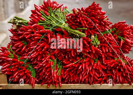 Pile of harvested red chili peppers on market stall Stock Photo