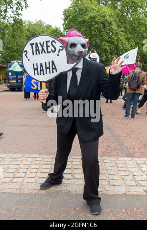 London, UK. 26th Aug, 2021. A protester seen wearing a costume and holding a speech bubble saying 'Taxes haha' seen during the protest.Extinction Rebellion's Impossible Rebellion protest continues as protesters march from Hyde Park in London under the theme 'Stop The Harm' against climate change, global warming, and plans to target the root cause of the climate and ecological crisis and to demand the government divest from fossil fuel companies. Credit: SOPA Images Limited/Alamy Live News Stock Photo