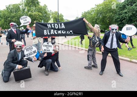 Protesters seen wearing costumes and holding a banner reading 'Media blackout' during the protest.Extinction Rebellion's Impossible Rebellion protest continues as protesters march from Hyde Park in London under the theme 'Stop The Harm' against climate change, global warming, and plans to target the root cause of the climate and ecological crisis and to demand the government divest from fossil fuel companies. (Photo by Dave Rushen / SOPA Images/Sipa USA)