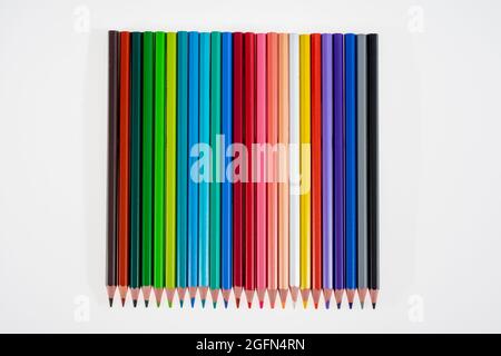 24 multicolored crayons on a white background, neatly arranged and sharpened. Hello School Stock Photo