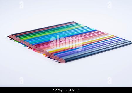 24 multicolored crayons on a white background, neatly arranged and sharpened. Hello School Stock Photo