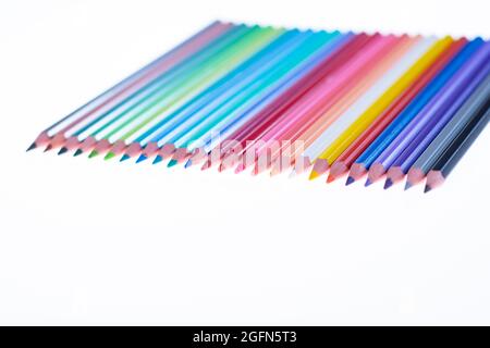 24 multicolored crayons on a white background, neatly arranged and sharpened. Hello School Stock Photo
