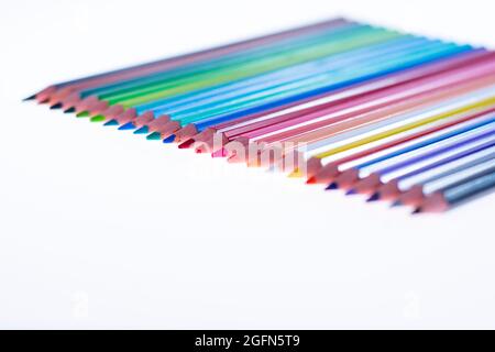 24 multicolored crayons on a white background, neatly arranged and sharpened. Hello School Stock Photo