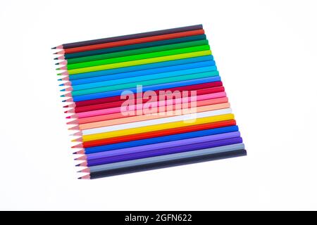 24 multicolored crayons on a white background, neatly arranged and sharpened. Hello School Stock Photo