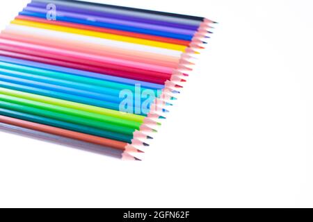 24 multicolored crayons on a white background, neatly arranged and sharpened. Hello School Stock Photo