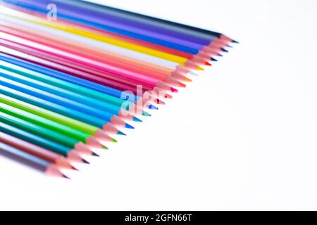 24 multicolored crayons on a white background, neatly arranged and sharpened. Hello School Stock Photo