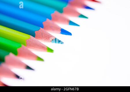 24 multicolored crayons on a white background, neatly arranged and sharpened. Hello School Stock Photo