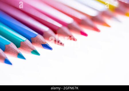24 multicolored crayons on a white background, neatly arranged and sharpened. Hello School Stock Photo