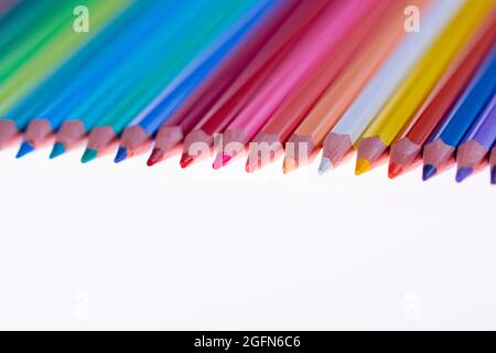 24 multicolored crayons on a white background, neatly arranged and sharpened. Hello School Stock Photo