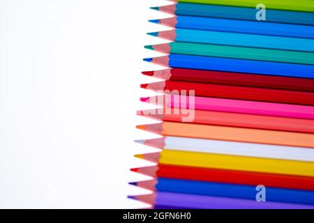 24 multicolored crayons on a white background, neatly arranged and sharpened. Hello School Stock Photo