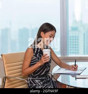 Businesswoman working at office drinking coffee Stock Photo