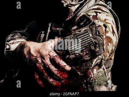 Photo shaded and wounded american soldier in uniform with usa patch on arm and blood splatter on it. Stock Photo