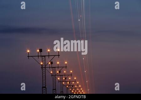 Light trail of airplane during approaching to airport. Night scene with landing lights. Stock Photo