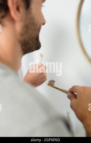 happy gay brushing teeth near boyfriend in bathroom Stock Photo