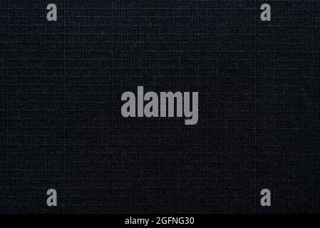 Textile. The material is gray or black in a small check. Fabric background with small squares. Texture Stock Photo