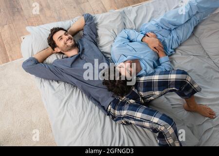 top view of happy gay couple in pajamas resting on bed Stock Photo