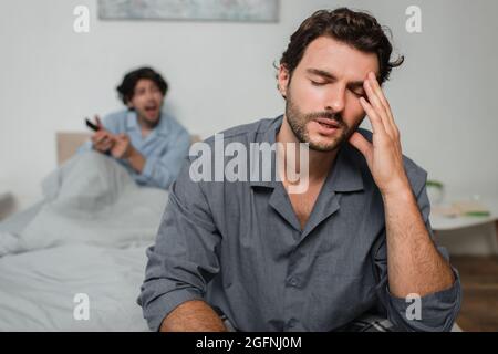 man suffering from headache while quarrelling with boyfriend Stock Photo