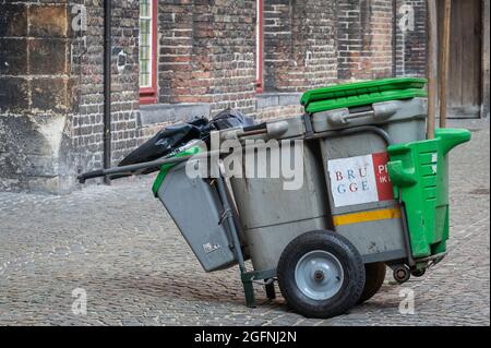 Brugge, Flanders, Belgium - August 4, 2021: Closeup of gray-green city-run official trashcans on wheels to be pushed by humans. Stock Photo