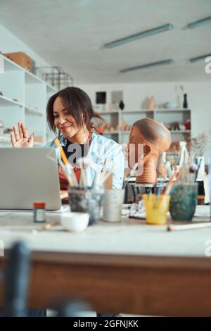 Charming female potter using notebook in pottery workshop Stock Photo