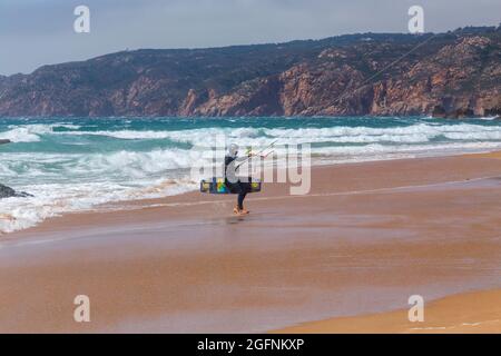 Guincho beach sea with surfers doing kitesurf and with the blue sky in the background, Cascais, Portugal Stock Photo