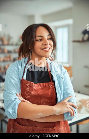 Beautiful young woman ceramist standing in pottery workshop Stock Photo
