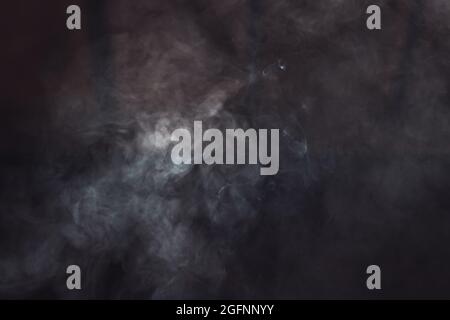 smoke in the dark swirls beautifully Stock Photo