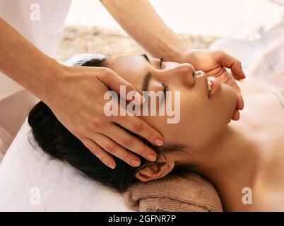 Asian woman receives head massage and enjoys relaxing at spa. Anti-stress head massage, close up Stock Photo