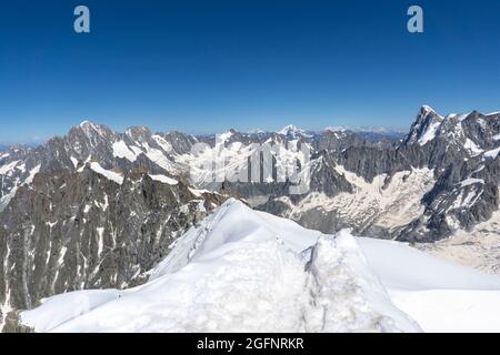 A panoramic view of European Alps on a sunny day. Mount Blanc as a highest mountain in Europe covered with snow and glacier. Climbers and mountaineers Stock Photo