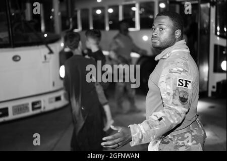 Members of the 386th Expeditionary Security Forces Squadron escort Afghanistan evacuees after arriving on a C-17 Globemaster III aircraft at Ali Al Salem Air Base, Kuwait, Aug. 24, 2021. The Department of Defense is committed to supporting the evacuation of American citizens, Special Immigration Visa applicants and other at-risk individuals from Afghanistan. (U.S. Air Force photo by Tech. Sgt. Eric Summers Jr.  via American PhotoArchive/Alamy). Stock Photo