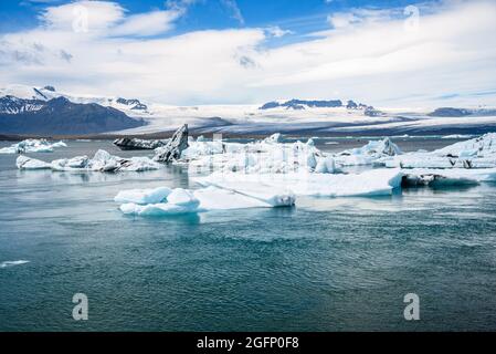 Glacial lagoon dotted with icebergs on a partly cloudy summer day Stock Photo
