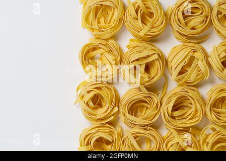 Fettuccine italian pasta isolated on white background. Raw tagliatelle nests isolated on white background. Traditional Italian pasta Stock Photo