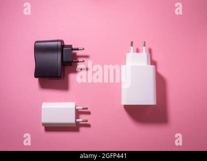 white and black usb charging blocks on a pink background Stock Photo