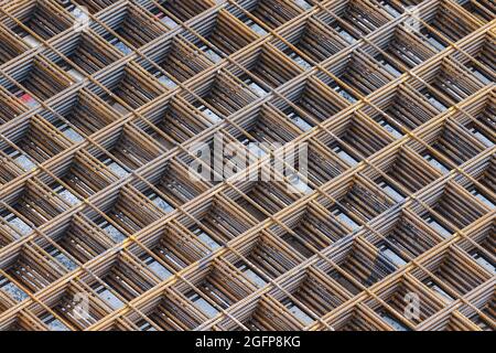 Metal square grid pattern formed by twisted steel interwoven rods or bars. Abstract background of square shapes, right angles and diagonal lines Stock Photo