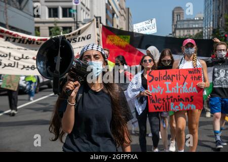 Washington, USA. 26th Aug, 2021. An activist with a bullhorn leads pro-Palestinian activists protesting a visit to the White House by Israel's Prime Minister in Washington, DC on August 26, 2021. (Photo by Matthew Rodier/Sipa USA) Credit: Sipa USA/Alamy Live News Stock Photo