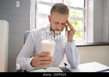 Person Holding Coffee Cup Having Headache And Migraine Stock Photo