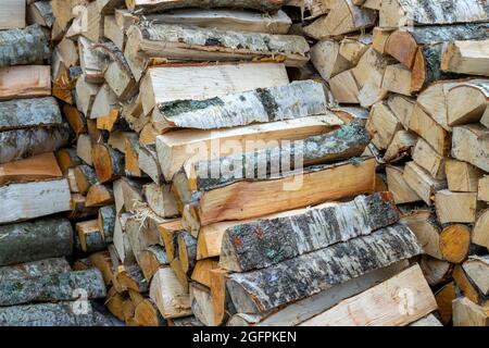 Woodpile of chopped and stacked firewood for the fireplace. Stock Photo
