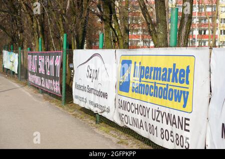 POZNAN, POLAND - Feb 23, 2015: The Row of advertising signs by a sidewalk Stock Photo