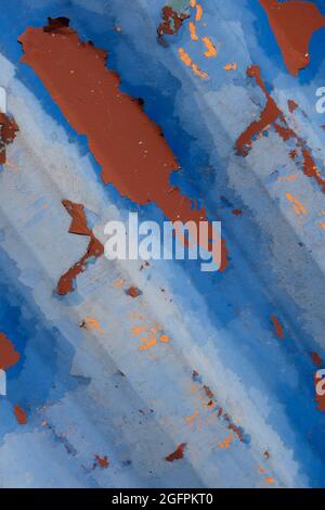 Textured rusted grunge corrugated background - peeling paint on old metal surface, painted blue with cracks and rust, an element of an old building Stock Photo