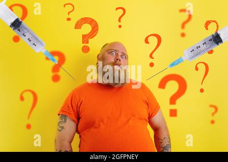Fat doubter man has doubts about covid-19 vaccine Stock Photo